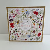 NQ Beautiful Day Wildflower Bloom birthday card with gold foil accents, featuring colorful wildflowers on a white background.