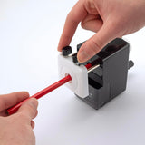 Rapesco Model 64 black desktop pencil sharpener on a desk, compact stationery and desk accessory for sharpening pencils.