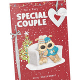 UK Greetings Boofles sitting on couch Christmas card featuring a cute couple design for the holiday season.