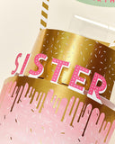 UK Greetings 3D pop-up sister birthday card featuring a colorful cake design with vibrant illustrations and festive details.