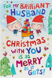 UK Greetings cartoon couple and festive scene Christmas card, featuring colorful holiday-themed illustrations.
