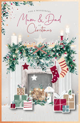 UK Greetings Christmas greeting card featuring a cozy fireplace scene with "Mum and Dad" messages for holiday wishes.