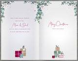 UK Greetings Christmas greeting card featuring a cozy fireplace scene with "Mum and Dad" presents for a heartfelt holiday message.
