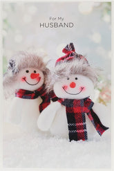 UK Greetings Quirky Snow Couple in Tartan Husband Christmas Card featuring festive winter scene with a cheerful couple in holiday attire.