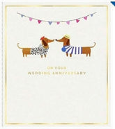 UK Greetings anniversary greeting card featuring playful sausage dogs and bunting, with a subtle watermark design.