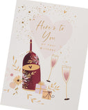 UK Greetings birthday greeting card featuring a wine bottle, glasses, and presents illustration.