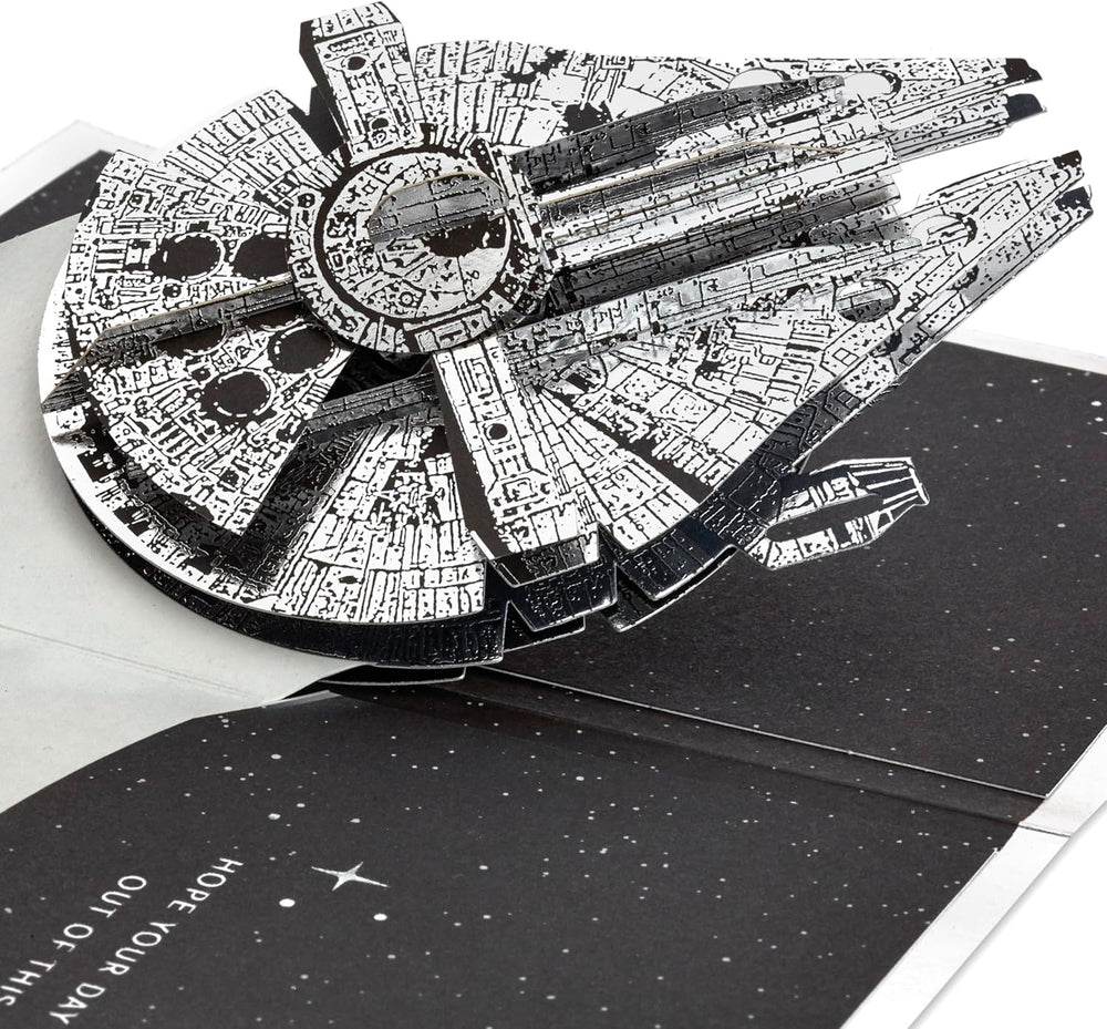 Hallmark 3D Star Wars Millennium Falcon pop-up birthday card with space-themed silver design and interactive starship features.