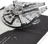 Hallmark 3D Star Wars Millennium Falcon pop-up birthday card with space-themed silver design and interactive starship features.