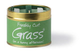 Lily-Flame Freshly Cut Grass scented tin candle with green label and metal lid, showcasing the candle's fresh grass scent.