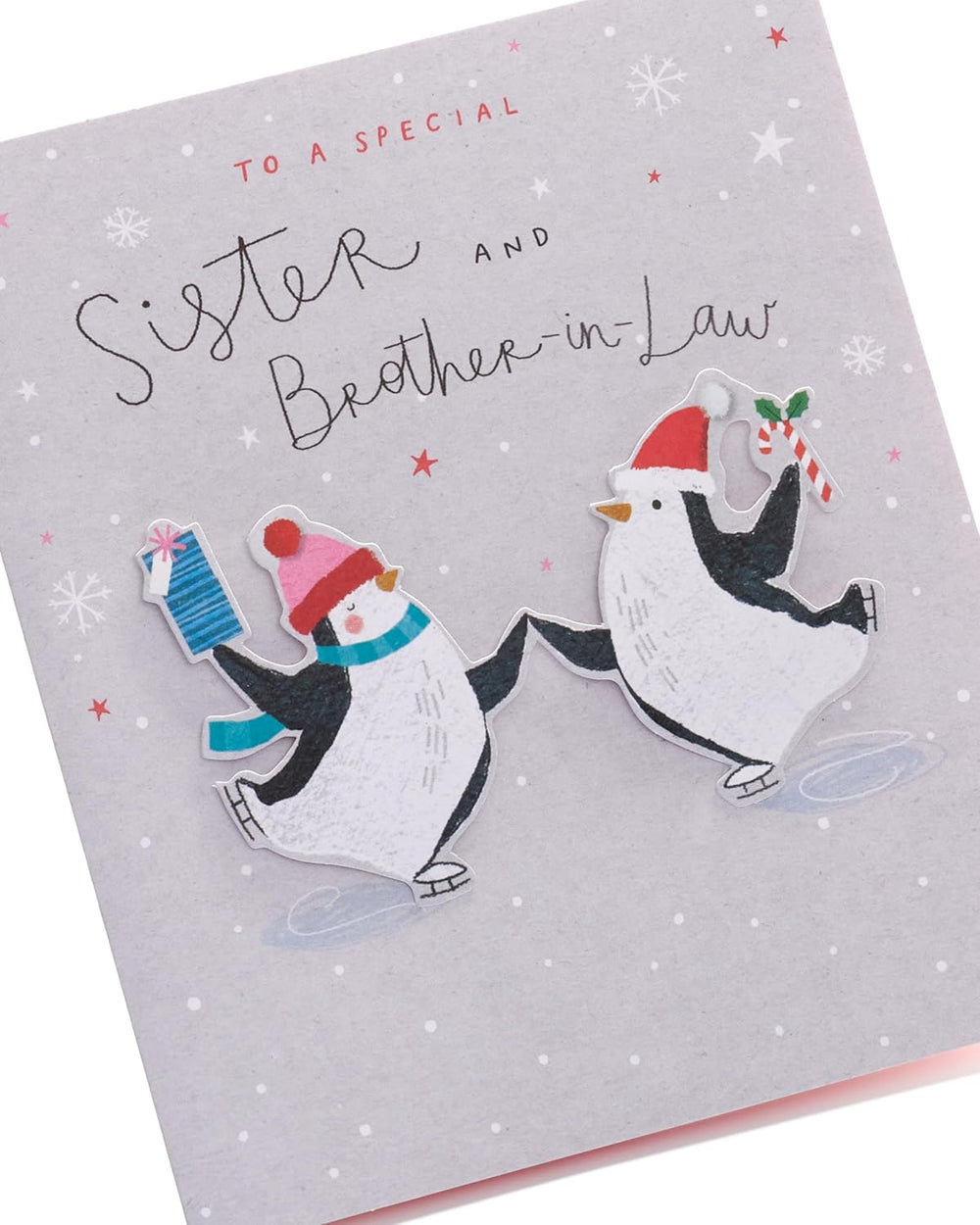UK Greetings Christmas card featuring adorable penguins ice skating, designed for sister and brother-in-law.