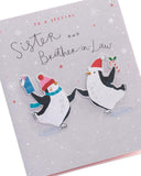 UK Greetings Christmas card featuring adorable penguins ice skating, designed for sister and brother-in-law.