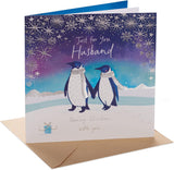 UK Greetings Christmas greeting card for husband featuring adorable penguins and a romantic festive design.