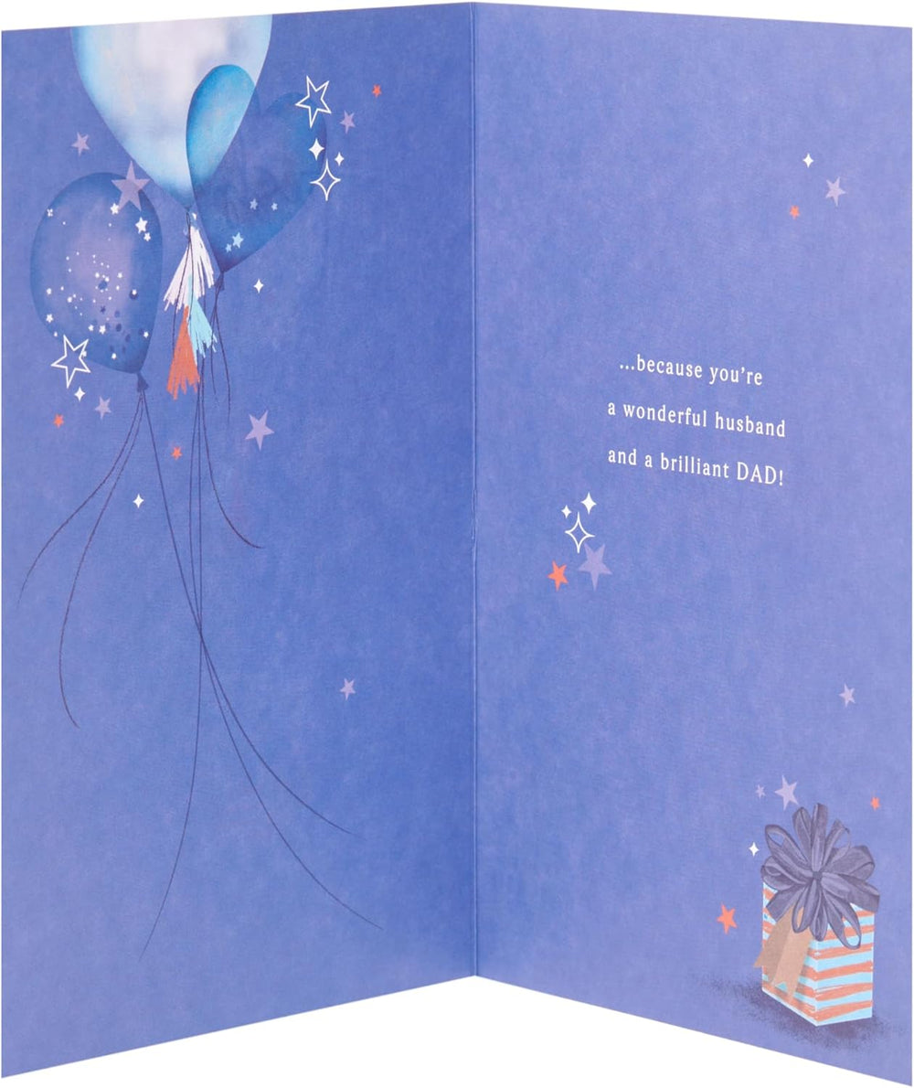 UK Greetings romantic Father's Day card for husband with gift and heart balloons design, featuring a heartfelt message and floral accents.