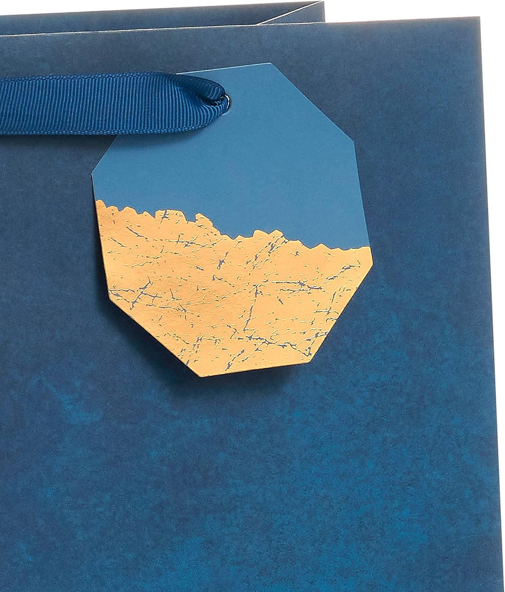 UK Greetings blue design large gift bag with handles, featuring decorative patterns for gift packaging.