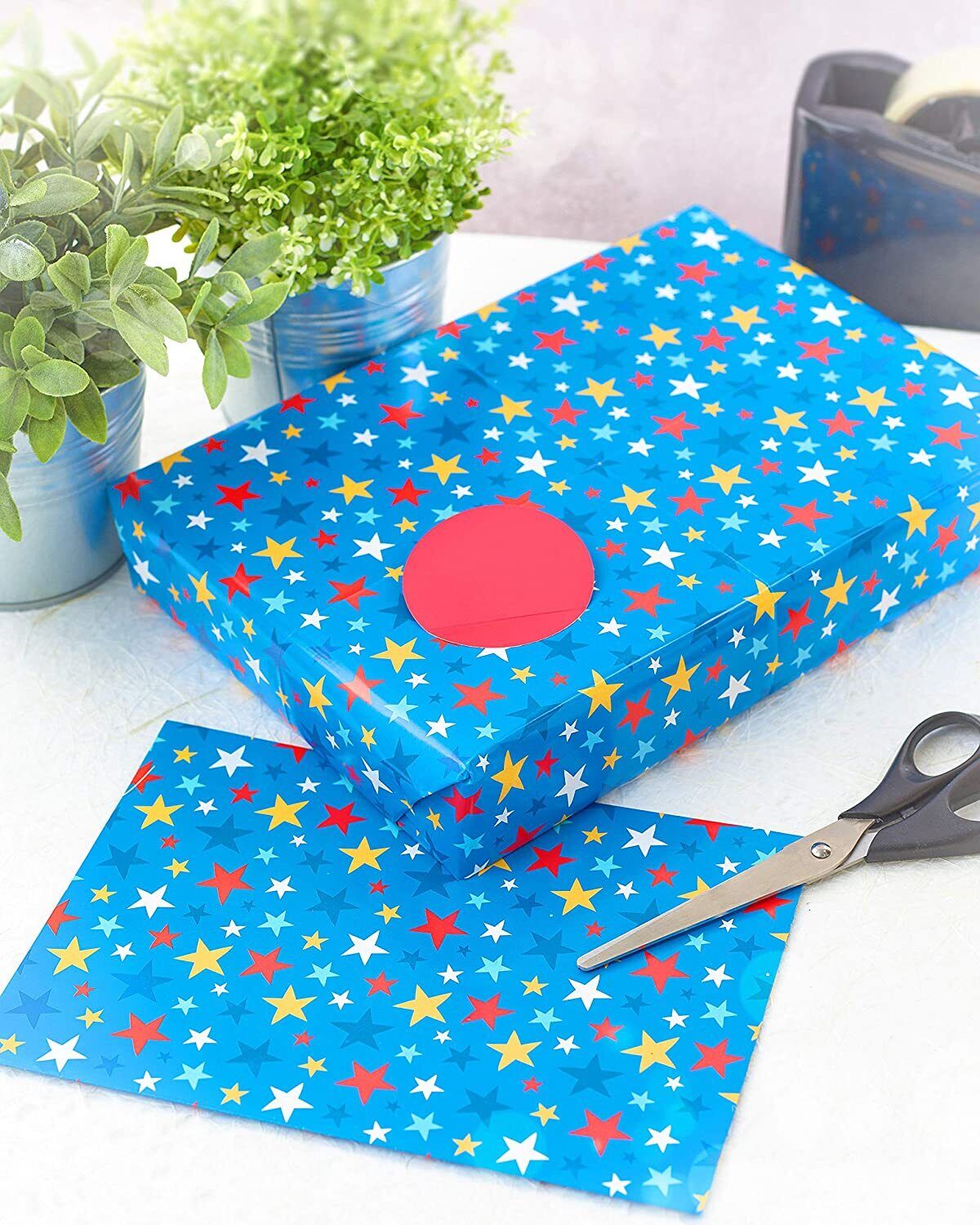 UK Greetings Blue Stars gift wrap with vibrant star pattern, ready for wrapping presents for any occasion.