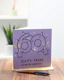 UK Greetings 60th birthday greeting card for him, her, or friend with purple design and celebratory motifs.