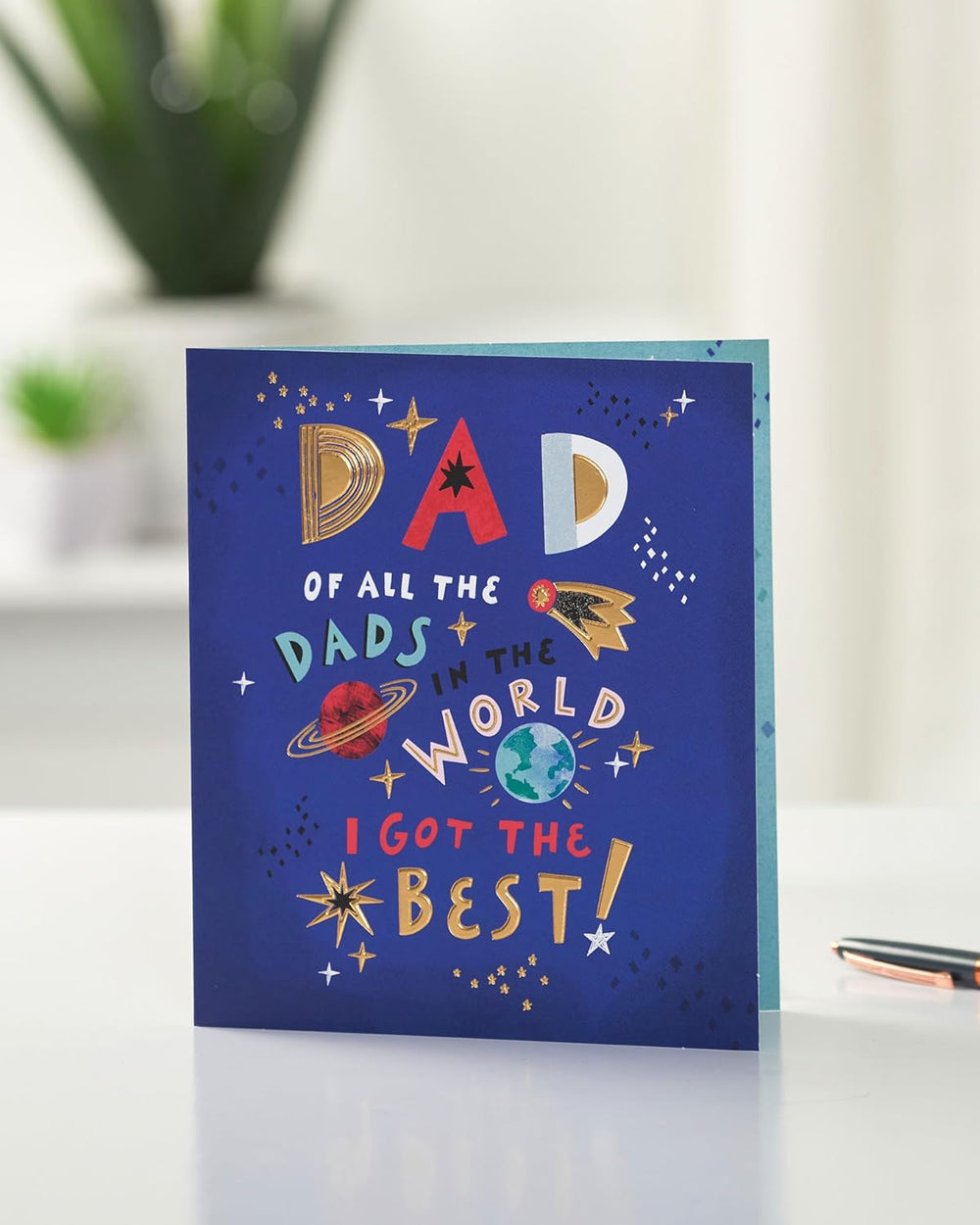 UK Greetings Father's Day card for Dad with a sweet space design, featuring colorful planets and stars on the front.