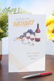 UK Greetings birthday greeting card featuring a watch and wine design, suitable for celebrating special occasions.