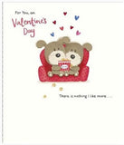 Cute couple on sofa greeting card from UK Greetings featuring a Woof Valentine's Day design with red foil finish, for him or her.