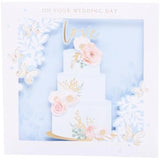 UK Greetings wedding greeting card with 3D cake design, featuring layered cake visuals and elegant wedding motifs.