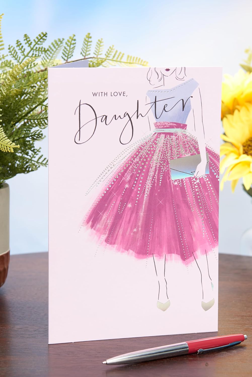 UK Greetings birthday card for daughter featuring a purple dress design from the Thinking of You range, with colorful floral accents.