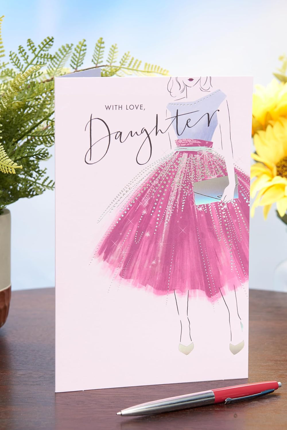 UK Greetings birthday card for daughter featuring a purple dress design from the Thinking of You range, with colorful floral accents.