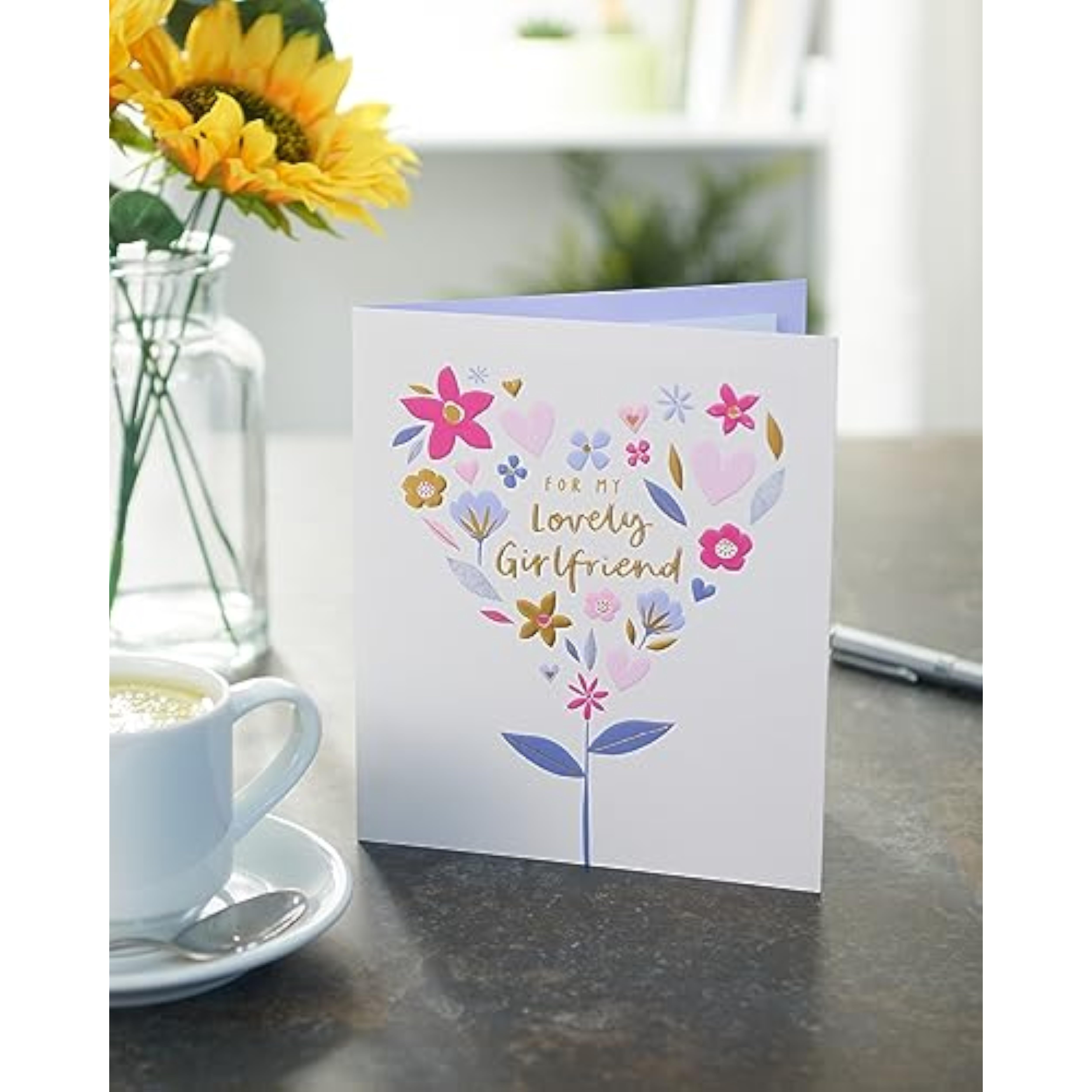 UK Greetings birthday card for girlfriend featuring a floral heart design, perfect for celebrating special occasions.