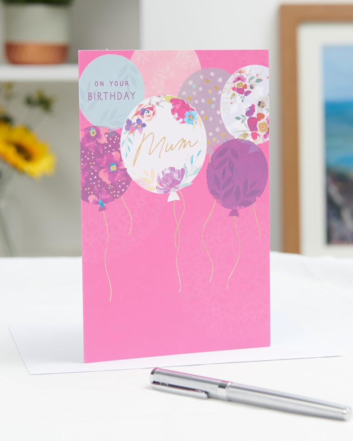 UK Greetings birthday card for mum with stylish balloons design, featuring colorful balloons and celebratory illustrations.