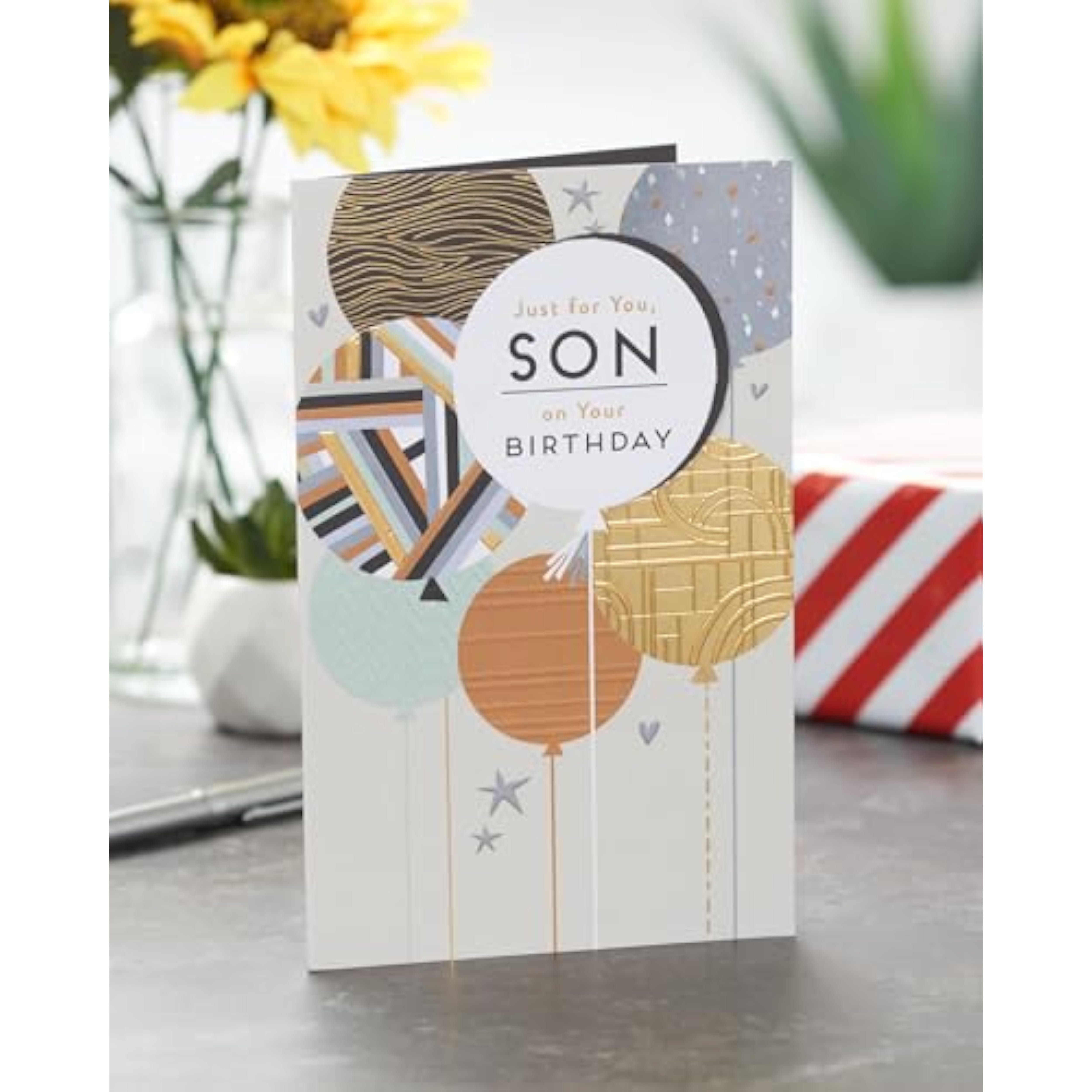 UK Greetings birthday card for son featuring colorful balloons design, celebrating with cheerful and vibrant imagery.