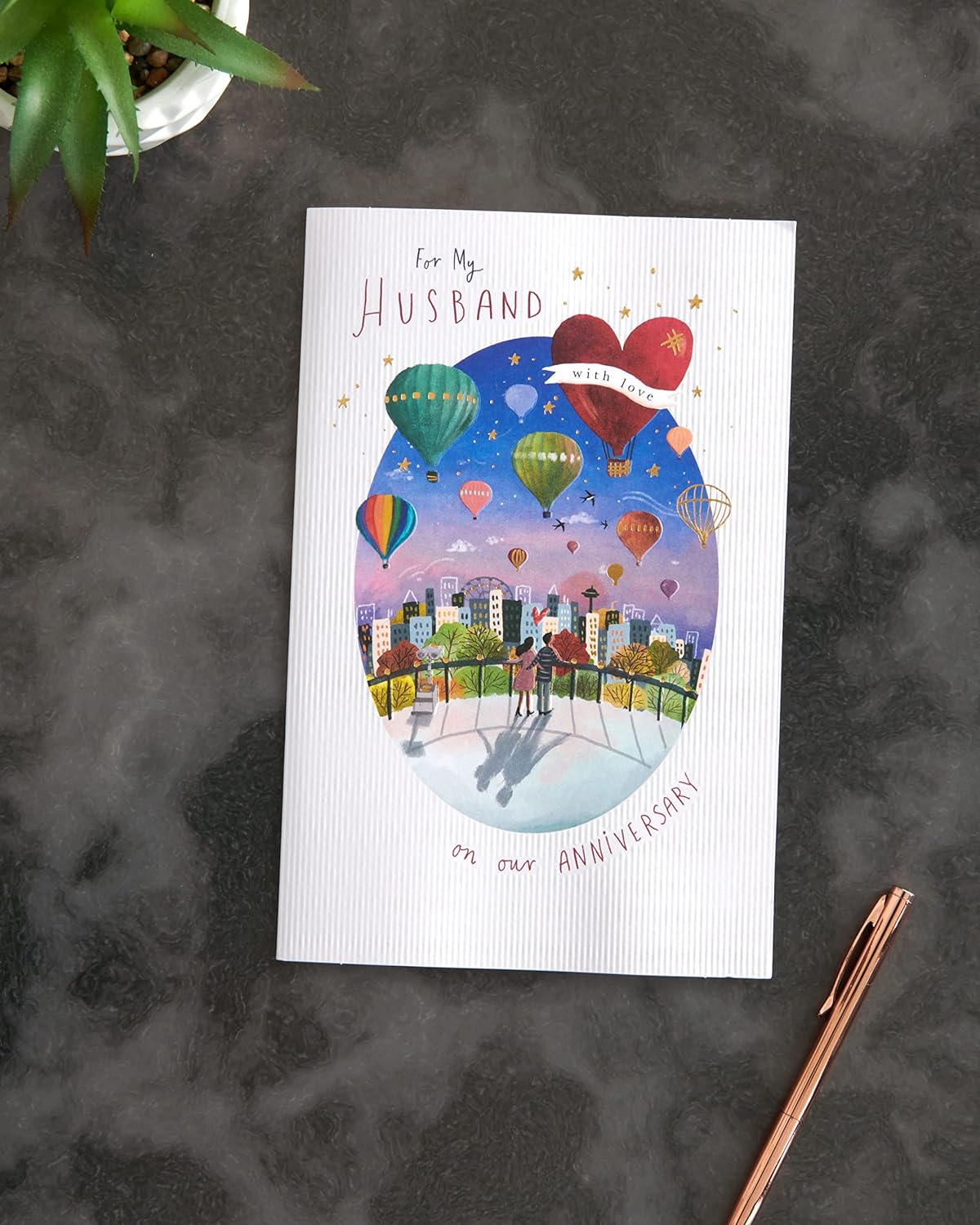 Colorful hot air balloon design husband anniversary greeting card by UK Greetings, featuring vibrant artwork and heartfelt message.