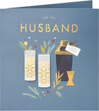 UK Greetings contemporary cocktail design birthday card for husband, featuring colorful drink illustrations and celebratory elements.