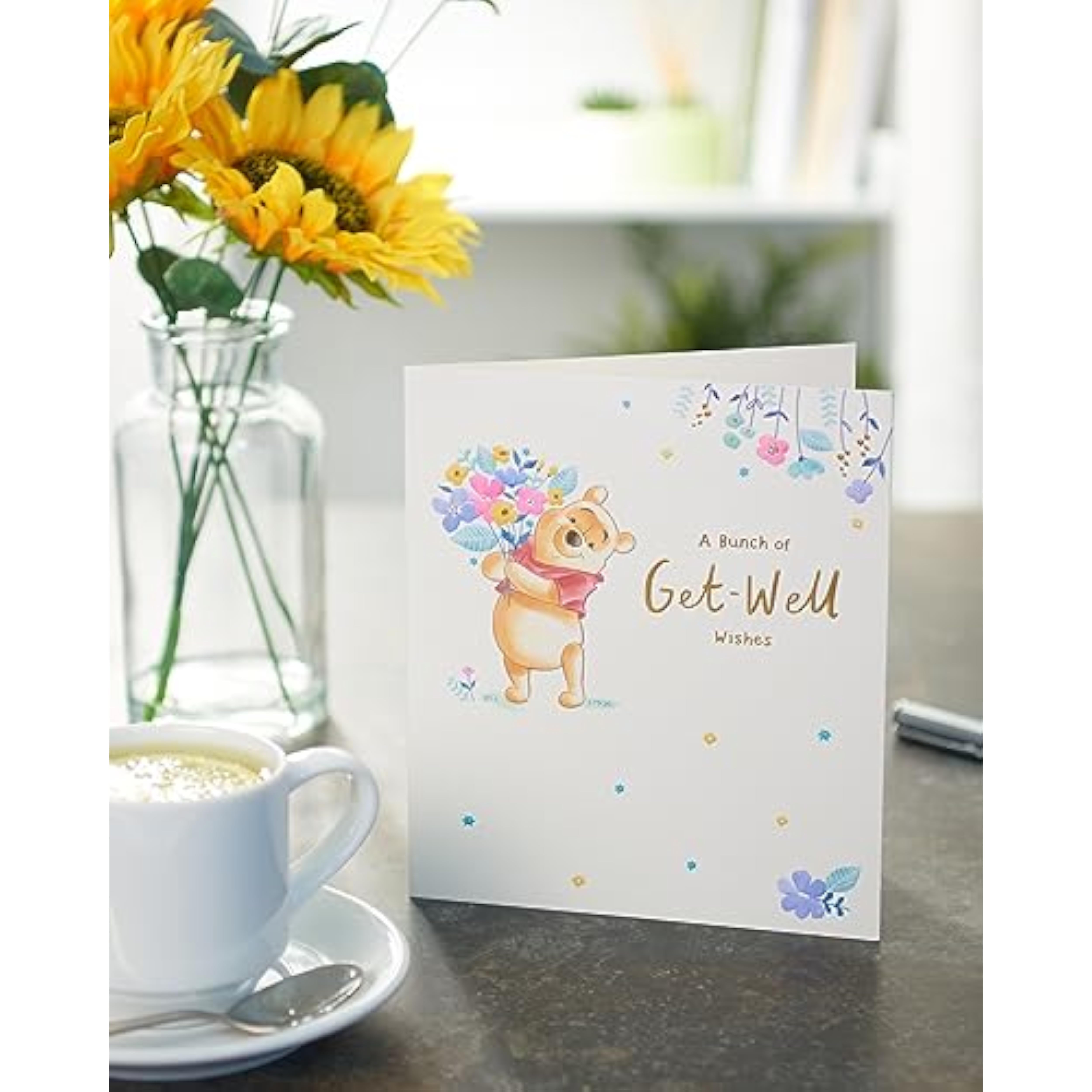 UK Greetings Disney Winnie the Pooh get well soon greeting card with colorful flower design and cheerful illustration.