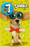 UK Greetings dog with big eyes 7th birthday card featuring a badge, colorful greeting card for children's birthday celebrations.