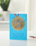UK Greetings Father's Day card for husband or dad featuring a gold medal design, celebrating special dad moments.
