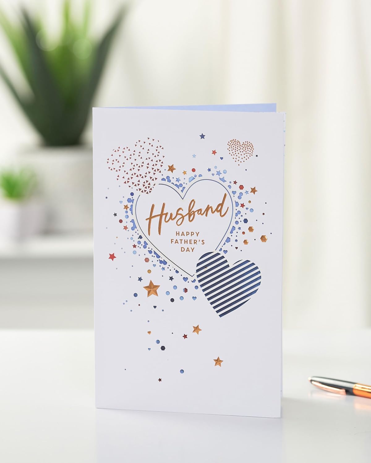 UK Greetings Father's Day card for husband featuring a love heart design, with colorful and festive greeting card imagery.