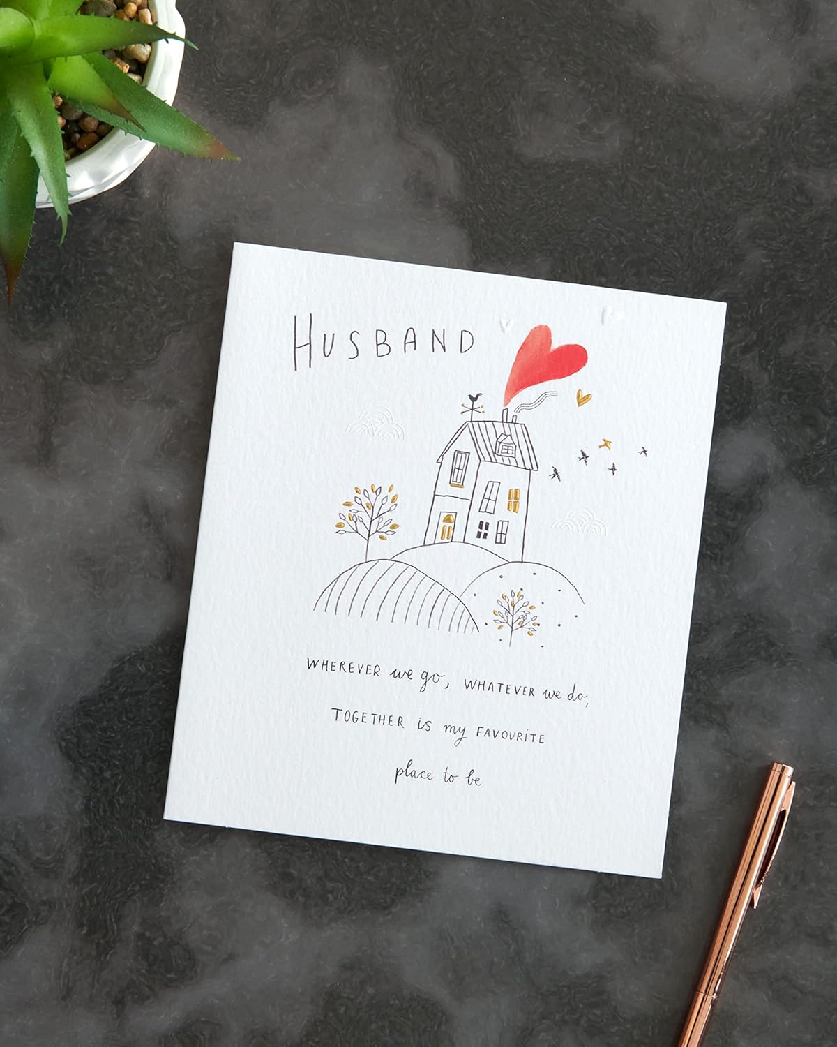 UK Greetings husband anniversary greeting card with envelope featuring a sweet drawing design, perfect for celebrating love.