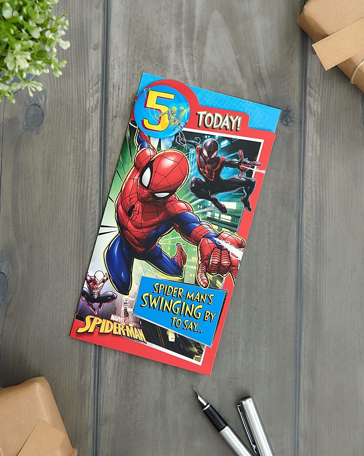 UK Greetings Marvel Spider-Man 5th birthday card with badge featuring Spider-Man in action, colorful comic-style design.