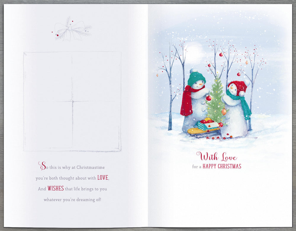 UK Greetings Christmas greeting card featuring snowmen decorating a tree for daughter and son-in-law, festive holiday scene.