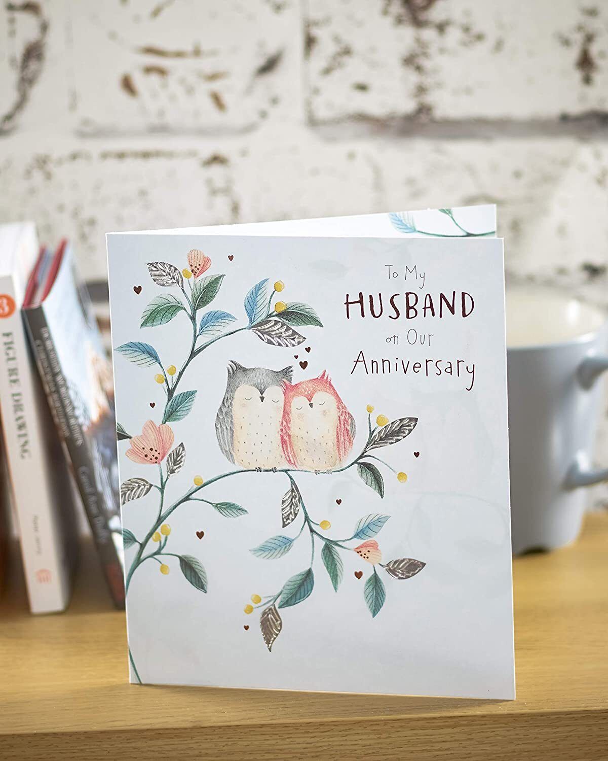UK Greetings anniversary greeting card for husband, featuring heartfelt message and decorative design for special occasion.