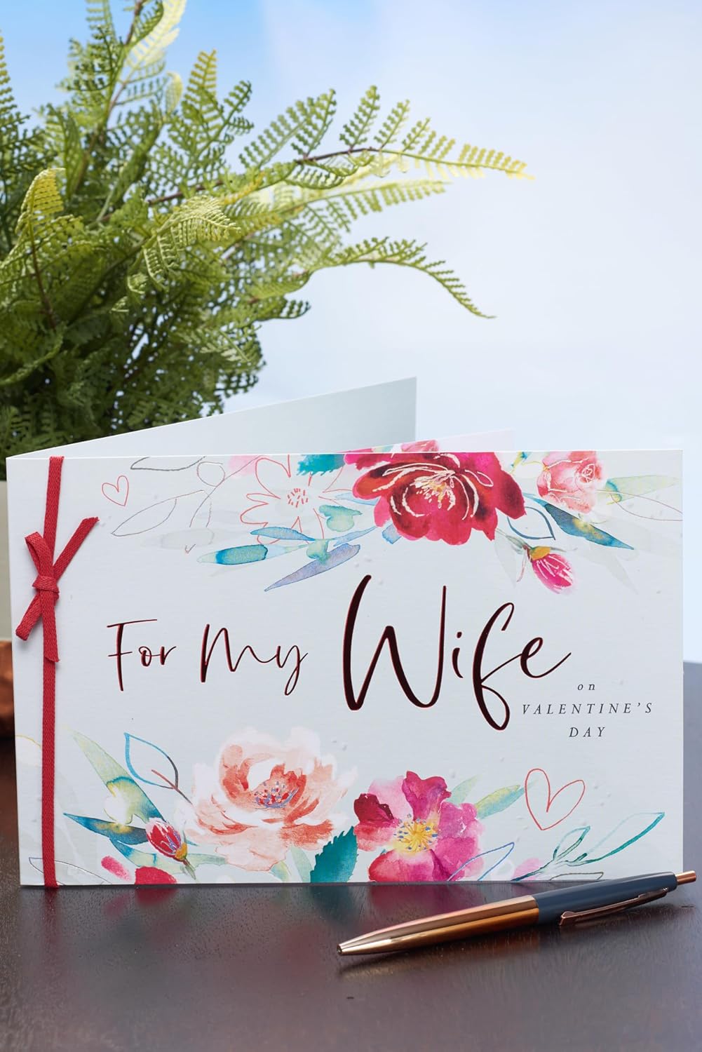UK Greetings Valentine's Day card for wife with pink floral design, featuring a heartfelt message on a colorful greeting card.