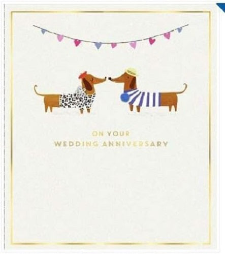 UK Greetings anniversary greeting card featuring playful sausage dogs and bunting, with a subtle watermark design.