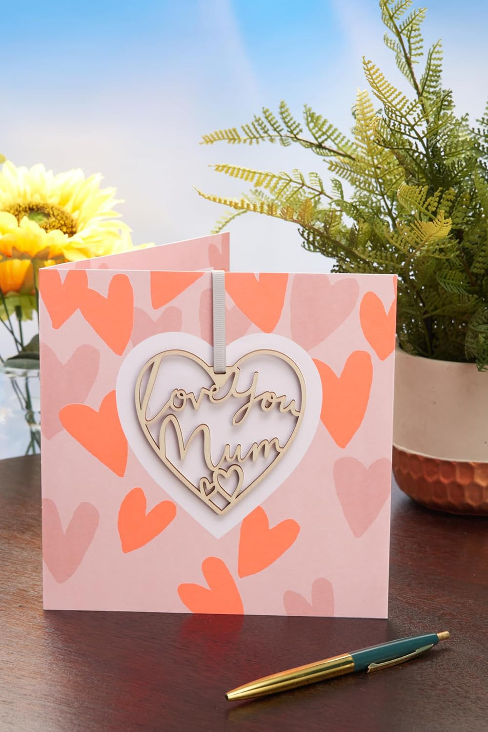 UK Greetings Mother's Day Card for Mum with keepsake heart attachment, featuring a heartfelt design for celebrating mothers.